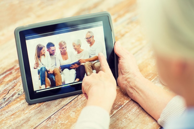 tecnologia, età, ricordi e concetto di persone - donna anziana felice con computer tablet pc che visualizza l'album di foto di famiglia a casa