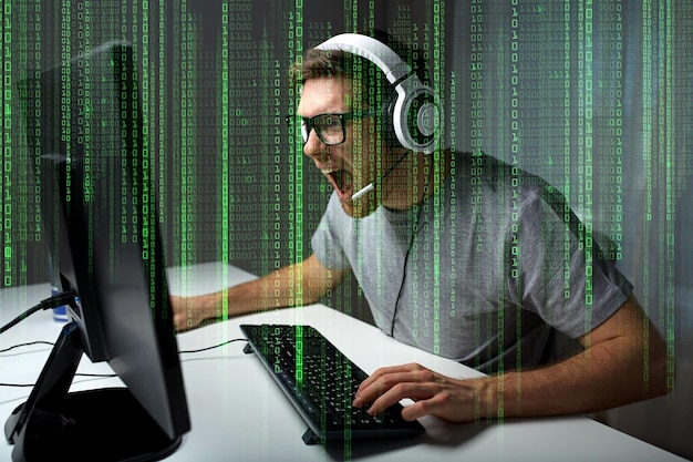 tecnologia, giochi, intrattenimento, giochiamo e concetto di persone - giovane urlante arrabbiato in cuffia con il computer che gioca a casa e streaming di playthrough o video walkthrough