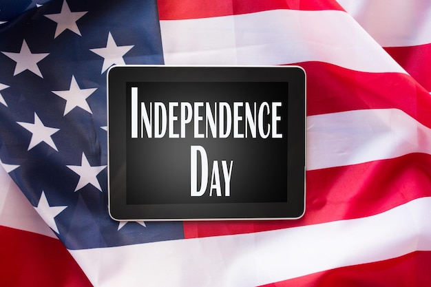 tecnologia, patriottismo, anniversario, feste nazionali e concetto di celebrazione - primo piano del computer tablet pc sulla bandiera americana e parole del giorno dell'indipendenza sullo schermo