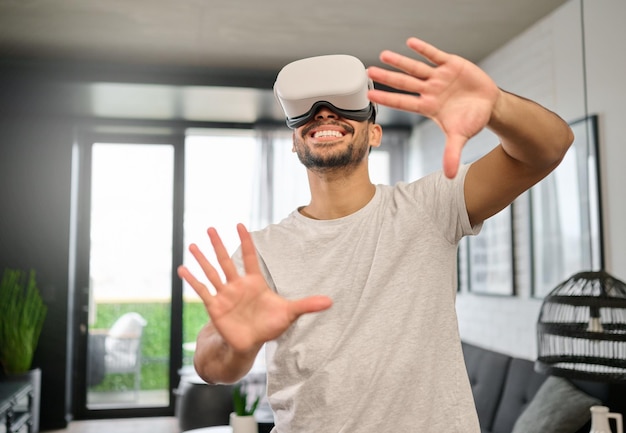 Tecnologia realtà virtuale e mani dell'uomo in casa con auricolare per lo streaming di giochi interattivi online e 3d Tecnologia digitale futuristica e ragazzo con occhiali vr per cyberspazio metaverso e giochi