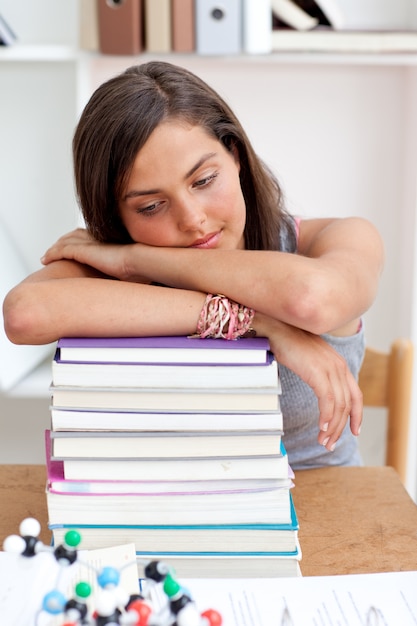 Teeenager stanco che dorme in una biblioteca