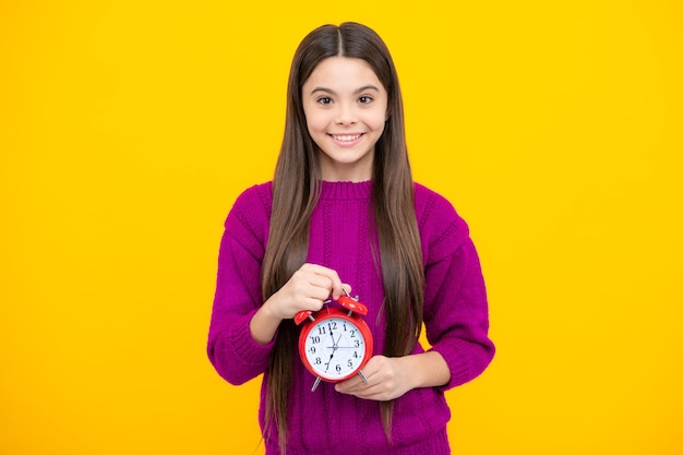 Teen studentessa con orologio isolato su sfondo giallo Bambino torna a scuola Concetto di istruzione e tempo