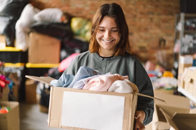 Teengirl volontaria che prepara scatole per le donazioni per le persone