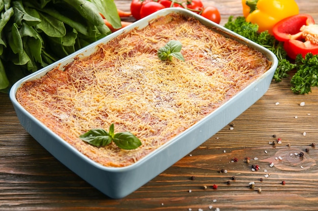 Teglia da forno di lasagne con spinaci sul tavolo