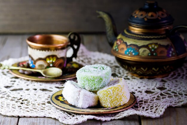 Teiera colorata con una tazza e dolci