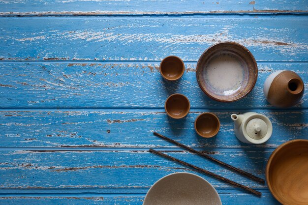 Teiera di ceramica sul fondo della tavola blu, vista superiore con lo spazio della copia