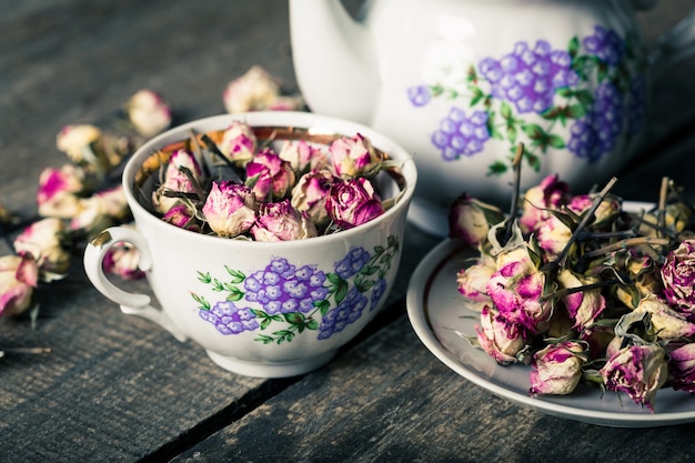 Teiera e tazza d'annata con i fiori di fioritura del tè