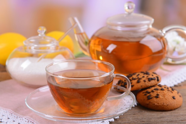 Teiera e tazza di tè sul tavolo su sfondo chiaro