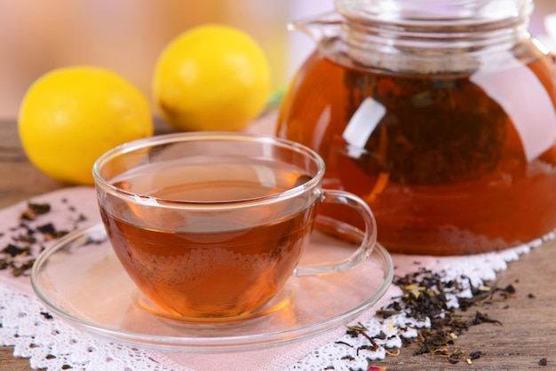 Teiera e tazza di tè sul tavolo su sfondo chiaro