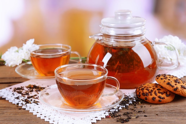 Teiera e tazze di tè sul tavolo su sfondo chiaro
