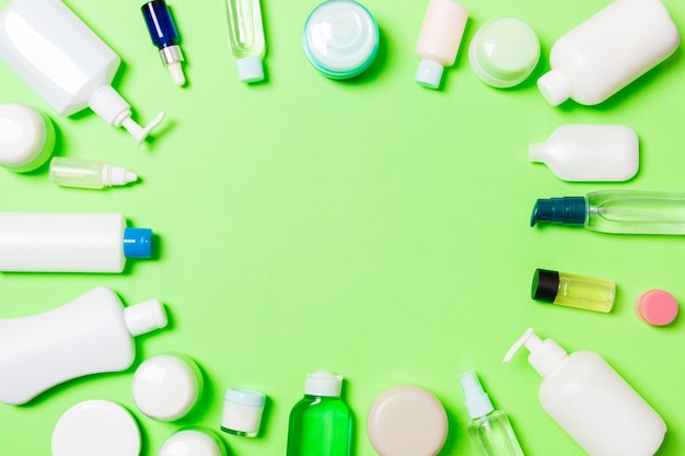 Telaio di bottiglia di plastica bodycare Composizione piatta laica con prodotti cosmetici su sfondo verde