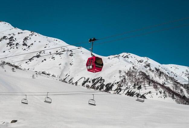 Telecabina sopra le montagne innevate contro il cielo