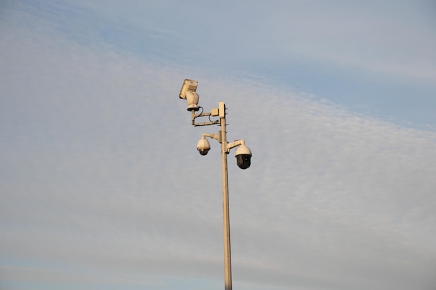 Telecamera di sicurezza CCTV che opera contro il cielo blu