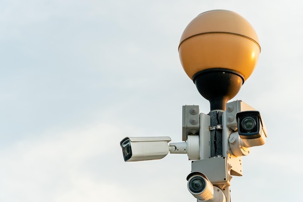 Telecamere a circuito chiuso in una custodia bianca protettiva su un lampione Telecamera di videosorveglianza da esterno installata per le strade della città per la sicurezza della tua proprietà e della tua famiglia