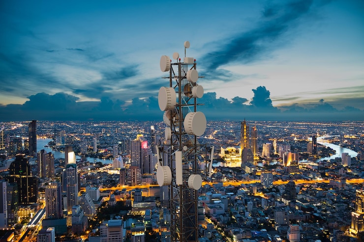Telecommunication tower with 5G cellular network antenna wave on night city background