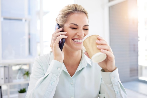 Telefonata donna d'affari e caffè in ufficio mattina e sorriso felice con conversazione divertente comunicazione e riflesso lente Dipendente donna beve e parla su smartphone mobile sul posto di lavoro