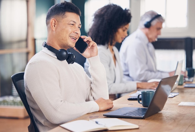 Telefonata uomo d'affari e comunicazione con networking b2b e trattativa con il laptop per la ricerca Connettività dipendente maschio con sorriso e telecomunicazione nell'area di lavoro di coworking con contatto