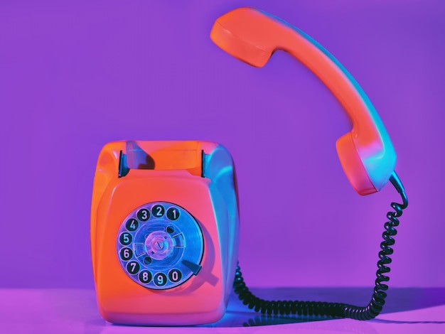 Telefono arancione vintage in luce al neon