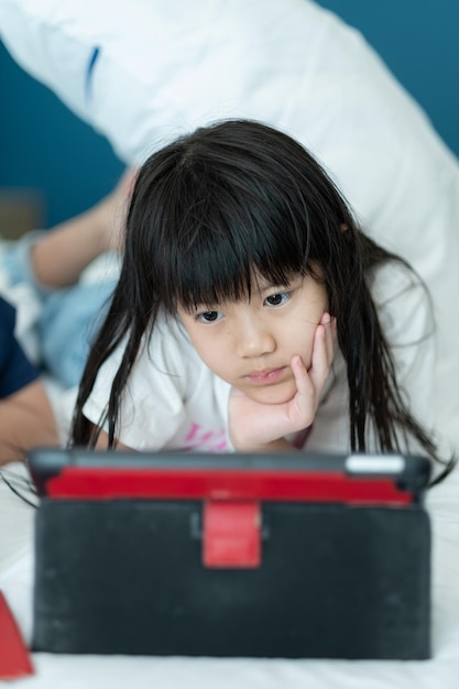 telefono cellulare cinese dipendente da bambini ragazza asiatica che gioca con lo smartphone bambino che guarda un cartone animato