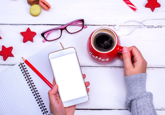 Telefono cellulare con schermo bianco vuoto nella mano sinistra femminile