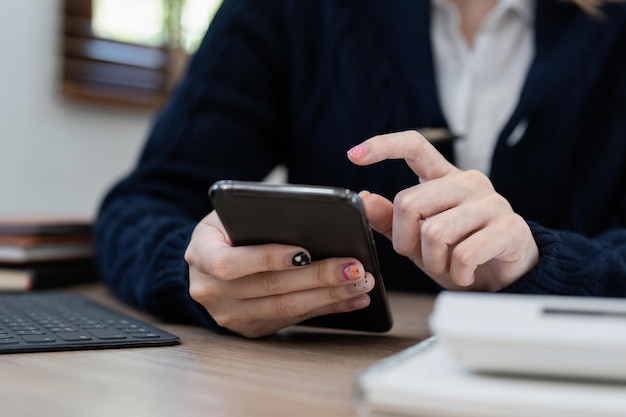 Telefono cellulare della tenuta della mano della donna di affari con il conto dell'applicazione del conto di risparmio bancario o il concetto di assicurazione o di risparmio