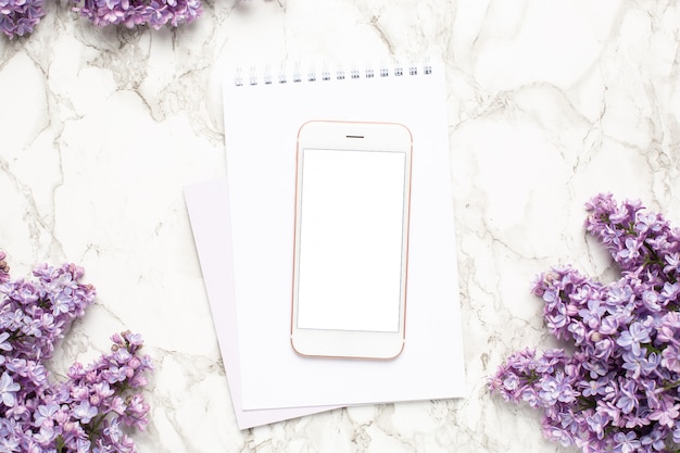 Telefono cellulare, notebook e fiori viola lilla