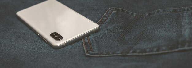Telefono cellulare Panorama bianco su blue jeans