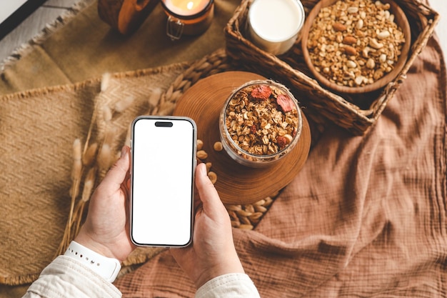 Telefono con schermo isolato sullo sfondo di granola fatta in casa buongiorno spazio per il tuo testo