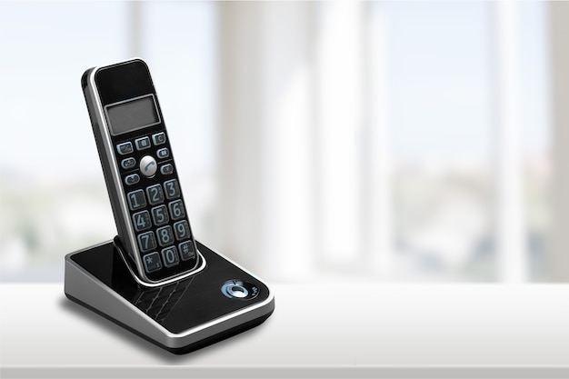 Telefono cordless moderno e stazione base isolata su bianco