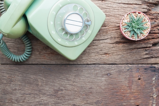 Telefono d&#39;annata e pianta del cactus sulla tavola di legno, vista superiore