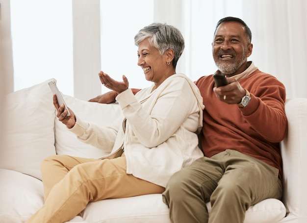 Telefono da ridere e coppia di anziani che guardano serie televisive, film comici o streaming, video in abbonamento o film divertenti, umorismo, cellulare e relax. Gli anziani guardano la televisione sul divano del salotto di casa.