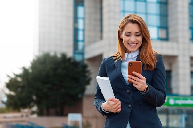 Telefono della holding della giovane donna di affari e invio di un testo