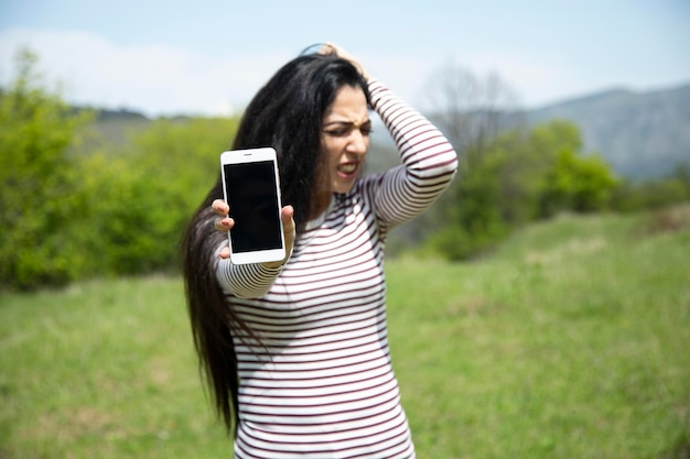 Telefono della mano della donna triste e mano nella testa