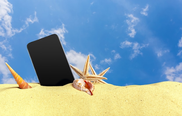 Telefono mobile di tocco in sabbia su una spiaggia