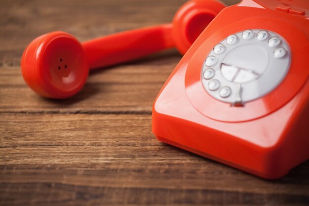 Telefono rosso sul tavolo di legno