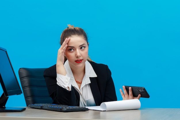 Telefono stanco della holding della giovane donna di affari e che si siede all'ufficio