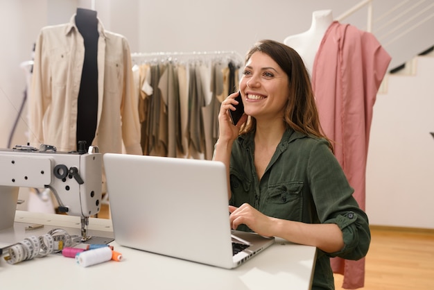 Telelavoratore donna lavora a casa con un laptop e uno smartphone