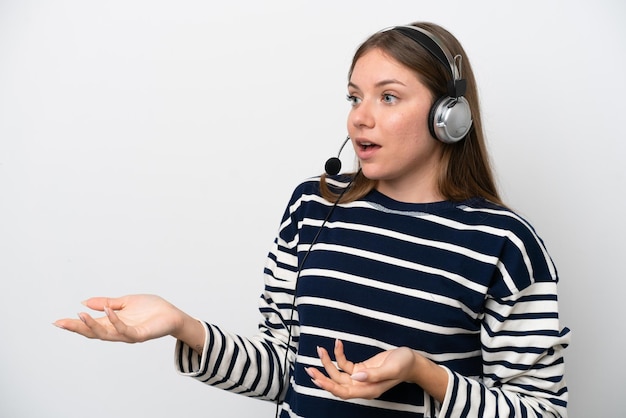 Telemarketer donna caucasica che lavora con un auricolare isolato su sfondo bianco con espressione facciale a sorpresa