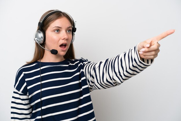 Telemarketer donna caucasica che lavora con un auricolare isolato su sfondo bianco rivolto verso l'esterno