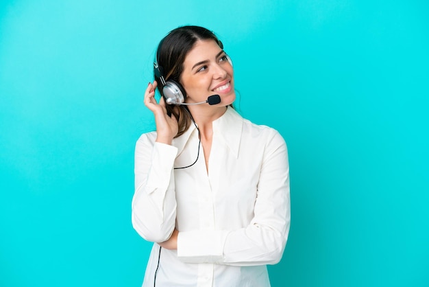 Telemarketer Donna italiana che lavora con un auricolare isolato su sfondo blu pensando a un'idea