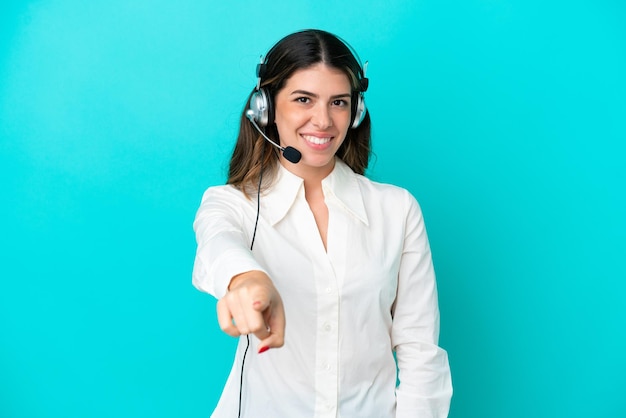 Telemarketer Donna italiana che lavora con un auricolare isolato su sfondo blu punta il dito contro di te con un'espressione sicura