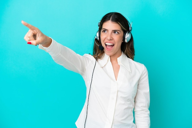 Telemarketer Donna italiana che lavora con un auricolare isolato su sfondo blu rivolto verso l'esterno