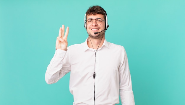 Telemarketer sorridente e dall'aspetto amichevole, mostrando il numero tre o il terzo con la mano in avanti, conto alla rovescia