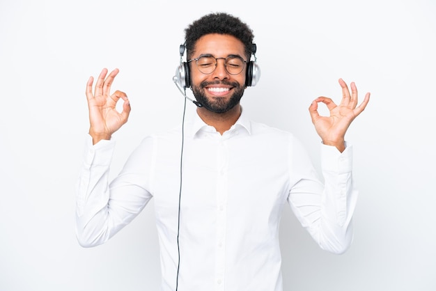 Telemarketer Uomo brasiliano che lavora con un auricolare isolato su sfondo bianco in posa zen