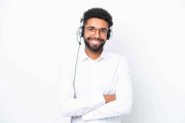 Telemarketer Uomo brasiliano che lavora con un auricolare isolato su sfondo bianco mantenendo le braccia incrociate in posizione frontale