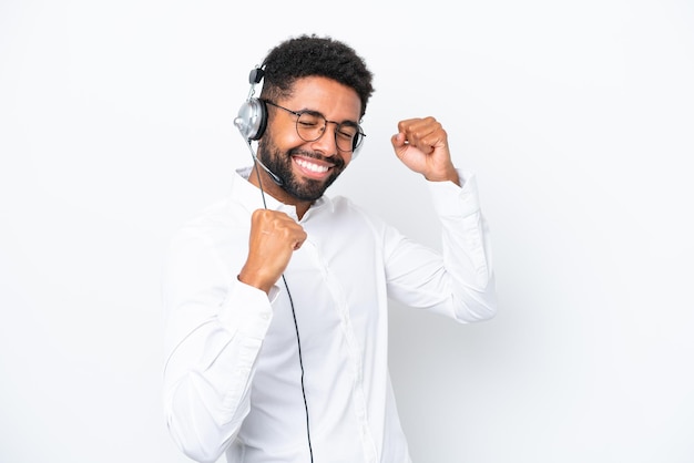 Telemarketer Uomo brasiliano che lavora con un auricolare isolato su sfondo bianco per celebrare una vittoria