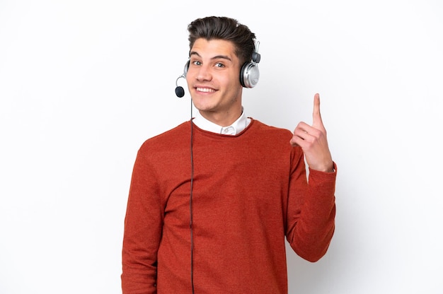 Telemarketer uomo caucasico che lavora con un auricolare isolato su sfondo bianco che punta con il dito indice una grande idea