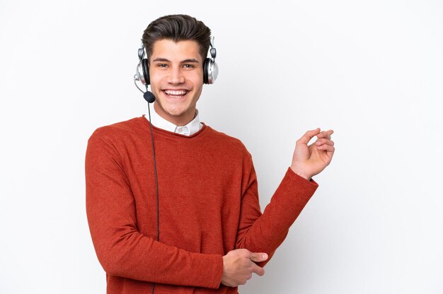 Telemarketer uomo caucasico che lavora con un auricolare isolato su sfondo bianco che punta il dito di lato