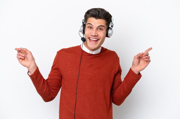 Telemarketer uomo caucasico che lavora con un auricolare isolato su sfondo bianco che punta il dito verso i laterali e felice