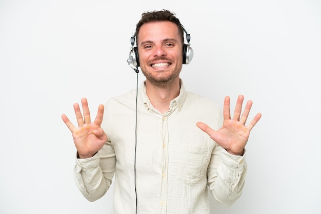 Telemarketer uomo caucasico che lavora con un auricolare isolato su sfondo bianco contando nove con le dita